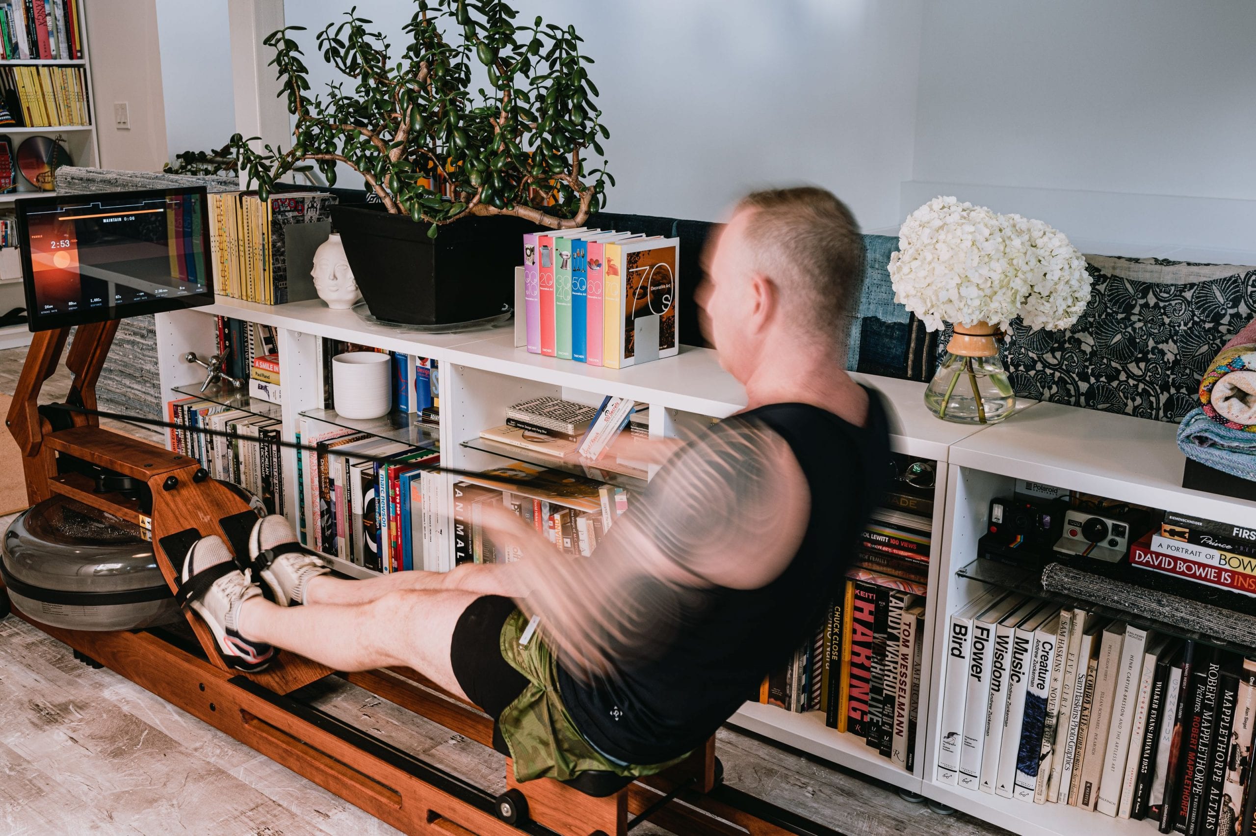 Man rowing by bookshelf